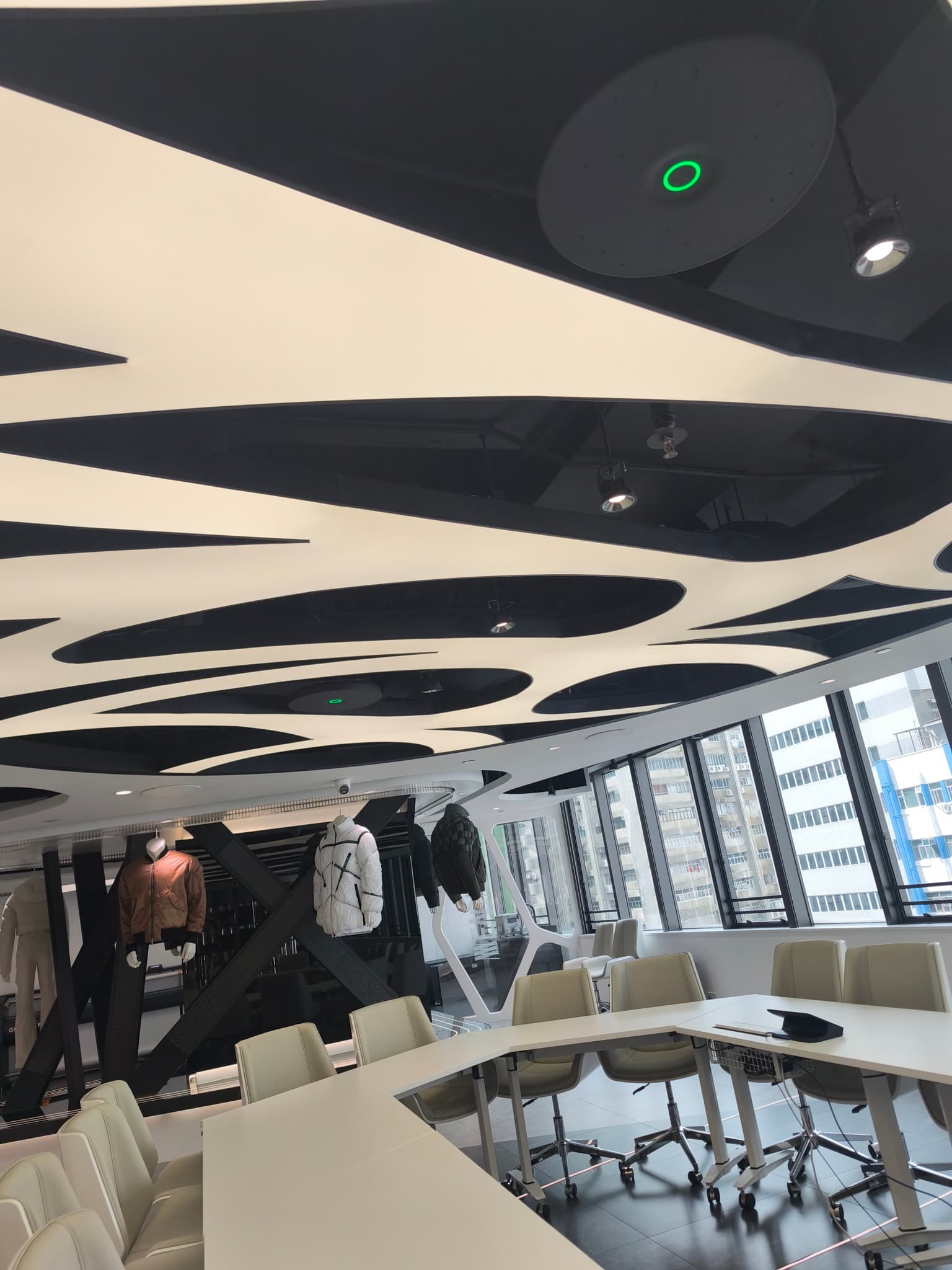 Two-floor showroom and meeting space with ceiling microphones and AV systems.