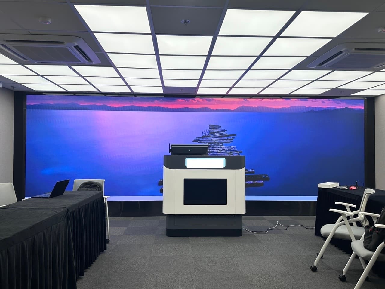 Interactive lectern in front of the LED display wall.